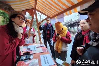 1月6日，“2024成都蒲江柑甜采摘節(jié)”上，記者見到了小萌（左一）和許多年輕人忙著做訪客接待、現(xiàn)場布置、票務(wù)核對、采摘服務(wù)等工作。人民網(wǎng)記者朱虹攝