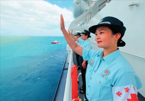 中國海軍“和平方舟”號醫(yī)院船結(jié)束訪問湯加時，任務(wù)官兵中的文職人員向歡送人群揮手告別（2023年8月4日攝）。徐巍攝/本刊