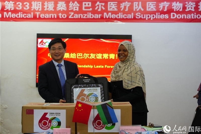 江蘇省蘇北人民醫(yī)院黨委書記束余聲捐贈物資與桑衛(wèi)生部首席秘書哈比巴。中國援桑醫(yī)療隊供圖