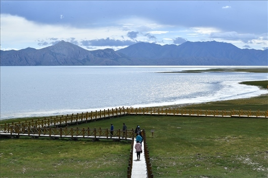△ 游客行走在青?，敹嗫h冬格措納湖畔的木棧道上。