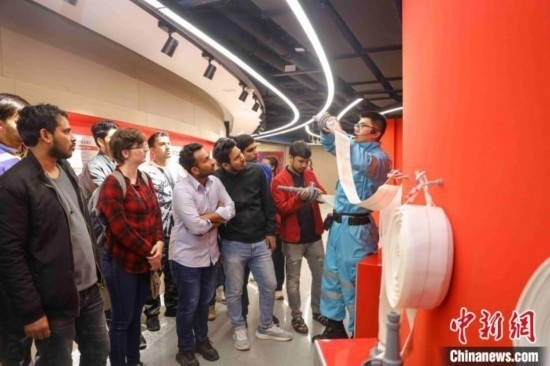 5月9日，工作人員指導(dǎo)留學(xué)生正確使用消防水帶。張鷹 攝