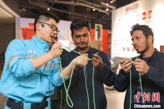 5月9日，工作人員指導(dǎo)留學(xué)生學(xué)習(xí)打繩結(jié)。張鷹 攝