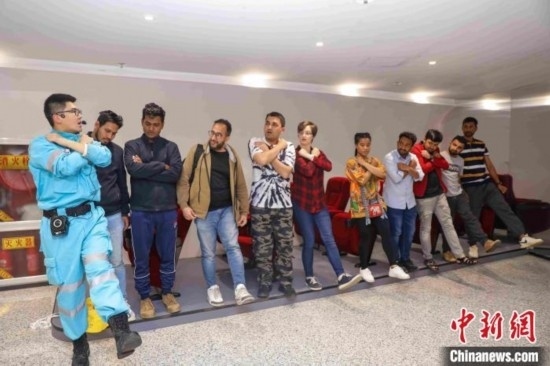 5月9日，工作人員指導(dǎo)留學(xué)生練習(xí)逃生技巧。張鷹 攝