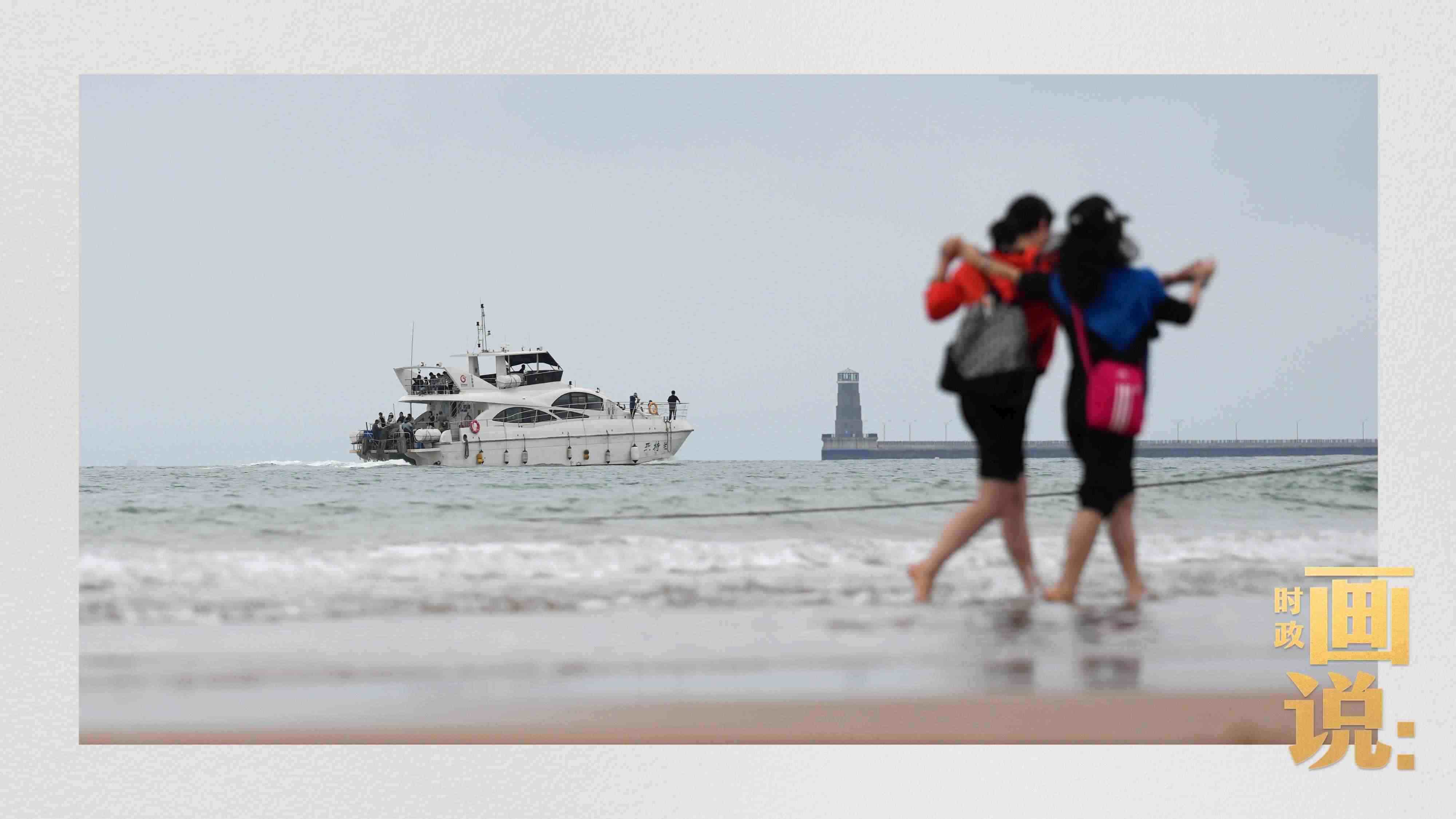 △日照陽光海岸綠道上的萬平口景區(qū)，一對游客在海浪中翩然起舞。