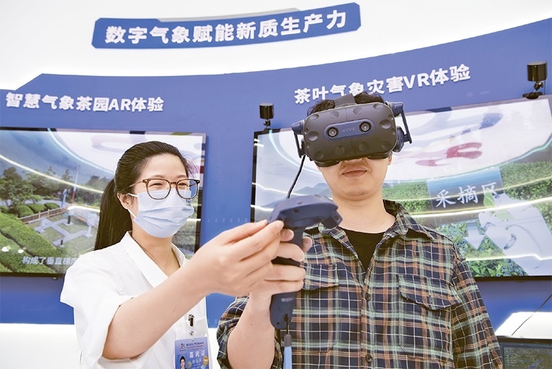 2024年5月23日，第七屆數(shù)字中國(guó)建設(shè)峰會(huì)現(xiàn)場(chǎng)體驗(yàn)區(qū)在福州海峽國(guó)際會(huì)展中心向?qū)I(yè)觀眾開放。本次現(xiàn)場(chǎng)體驗(yàn)區(qū)圍繞本屆峰會(huì)主題“釋放數(shù)據(jù)要素價(jià)值，發(fā)展新質(zhì)生產(chǎn)力”，設(shè)置“數(shù)字惠民”、“數(shù)字能力”、“數(shù)字基礎(chǔ)”、“數(shù)字生態(tài)”、“數(shù)字賦能”五大板塊。圖為一名觀眾（右）在數(shù)字氣象賦能新質(zhì)生產(chǎn)力展臺(tái)上進(jìn)行體驗(yàn)。 新華社記者 魏培全/攝