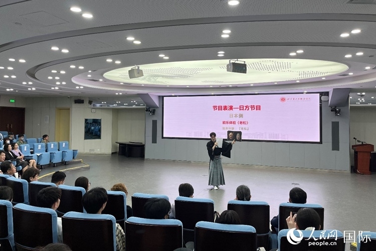 日本大學(xué)生介紹能樂知識。人民網(wǎng)記者 陳思攝