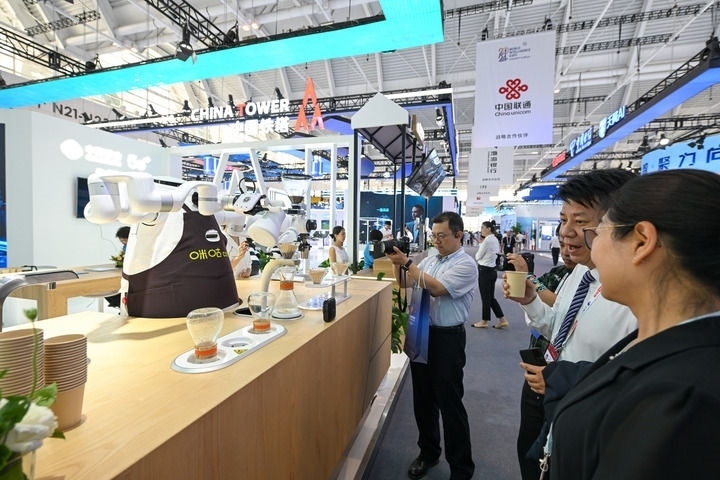 6月20日，與會者品嘗機器人沖調(diào)出的咖啡。新華社記者 孫凡越 攝