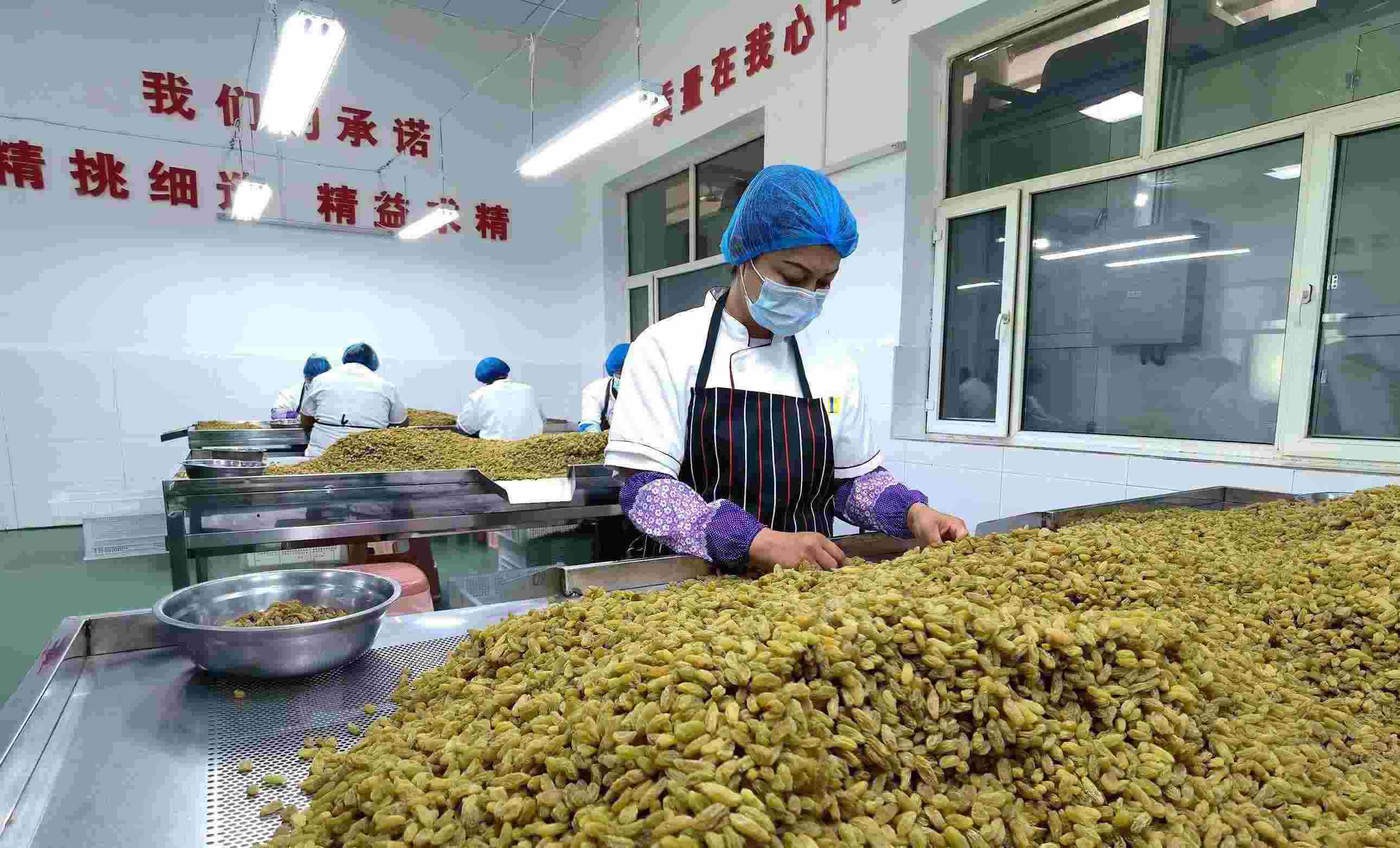 新疆吐魯番市高昌區(qū)亞爾鎮(zhèn)新城西門(mén)村，村民們?cè)诜謷咸迅伞? width=