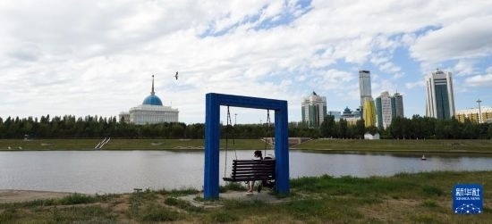 6月30日，一名女子在哈薩克斯坦首都阿斯塔納伊希姆河畔休息。新華社記者 王建華 攝