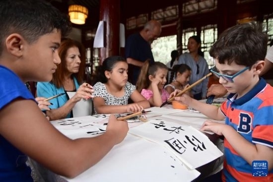 7月4日，在馬耳他桑塔露琪亞市的中國(guó)古典園林“靜園”，人們體驗(yàn)中國(guó)書法。新華社發(fā)（喬納森·博格 攝）