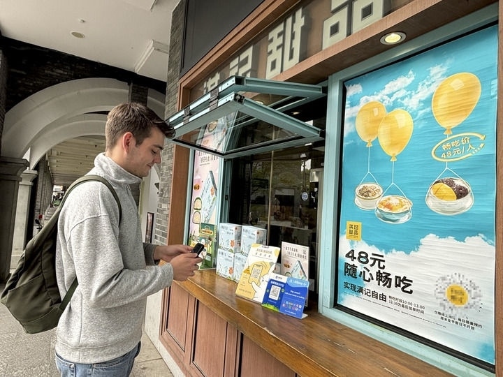來自德國的留學生理查德在杭州西湖邊一家商鋪使用支付寶掃碼支付（2024年4月11日攝）。新華社發(fā)