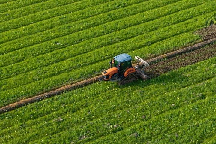 2024年3月19日，在湖南省常德市鼎城區(qū)謝家鋪鎮(zhèn)港中坪村，村民駕駛農(nóng)機翻耕田地（無人機照片）。新華社記者 陳思汗 攝