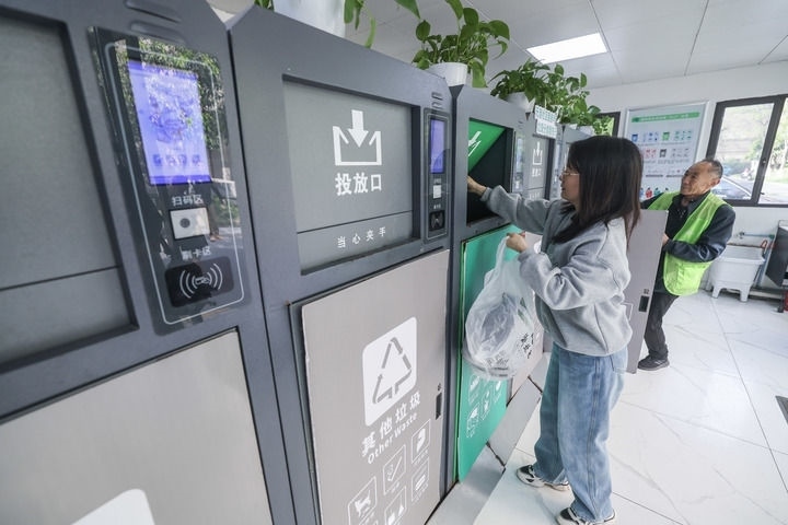 2024年4月10日，在浙江省湖州市吳興區(qū)飛英街道新華府小區(qū)內(nèi)，居民在垃圾分類智能系統(tǒng)的指導(dǎo)下進行垃圾分類投放，居民的投放情況將實時匯總到智慧服務(wù)平臺，會有相應(yīng)的積分獎勵。新華社記者 徐昱 攝