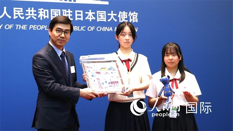 日本小大使向中國駐日本大使館臨時(shí)代辦施泳贈(zèng)送當(dāng)?shù)靥厣Y品。人民網(wǎng) 許可攝