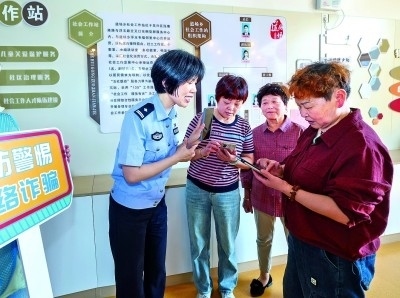 浙江湖州民警指導(dǎo)居民加入湖州“e企安”微信群，實(shí)時(shí)接收反詐信息。新華社發(fā)