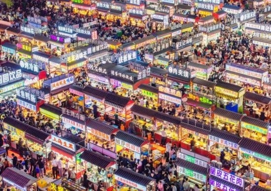 2024年4月21日，人們?cè)诤颖笔≌h小商品夜市品嘗美食（無人機(jī)照片）。新華社發(fā)（武志偉 攝）