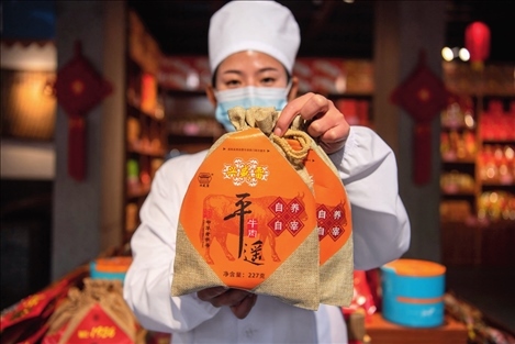 在位于山西省晉中市平遙縣的平遙古城南大街的一家平遙牛肉店內(nèi)，工作人員展示一款牛肉產(chǎn)品（資料照片）楊晨光攝 / 本刊