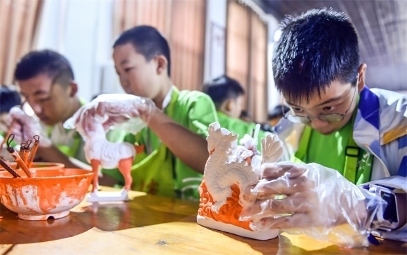 小朋友們?cè)诼尻?yáng)市孟津區(qū)朝陽(yáng)鎮(zhèn)南石山村體驗(yàn)唐三彩素胎施釉技藝。圖片來(lái)源：視覺(jué)中國(guó)