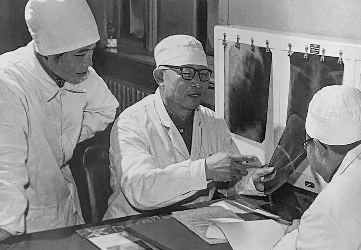 1980年1月16日，中日友好醫(yī)院首任院長辛育齡（中）在內(nèi)蒙古結(jié)核病院與胸外科醫(yī)師討論病例（翻拍照片）。 新華社發(fā)