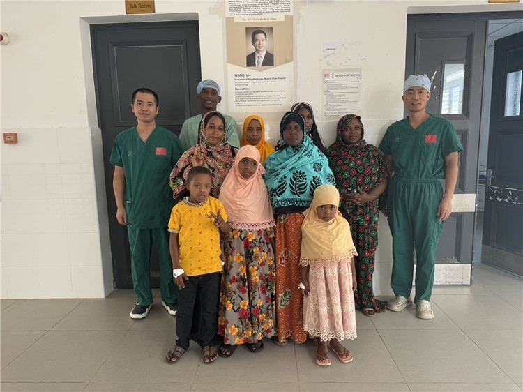 李廣（右一）和王林醫(yī)生與部分患者合影。中國(guó)援桑醫(yī)療隊(duì)供圖