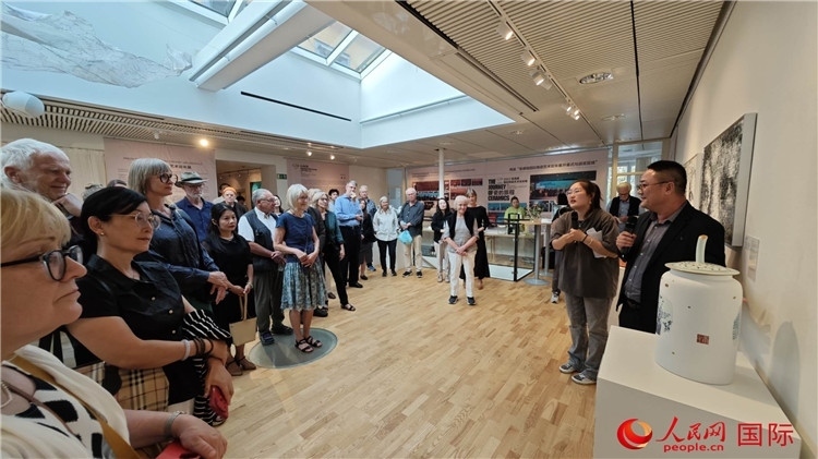 參展人、景德鎮(zhèn)陶瓷大學(xué)美術(shù)學(xué)院副院長邵長宗（右一）向來賓介紹參展作品。人民網(wǎng)記者 殷淼攝