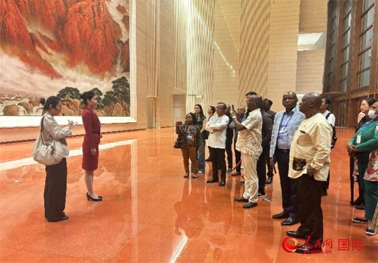 代表團(tuán)在入口處聽取講解。人民網(wǎng) 曹欣悅攝