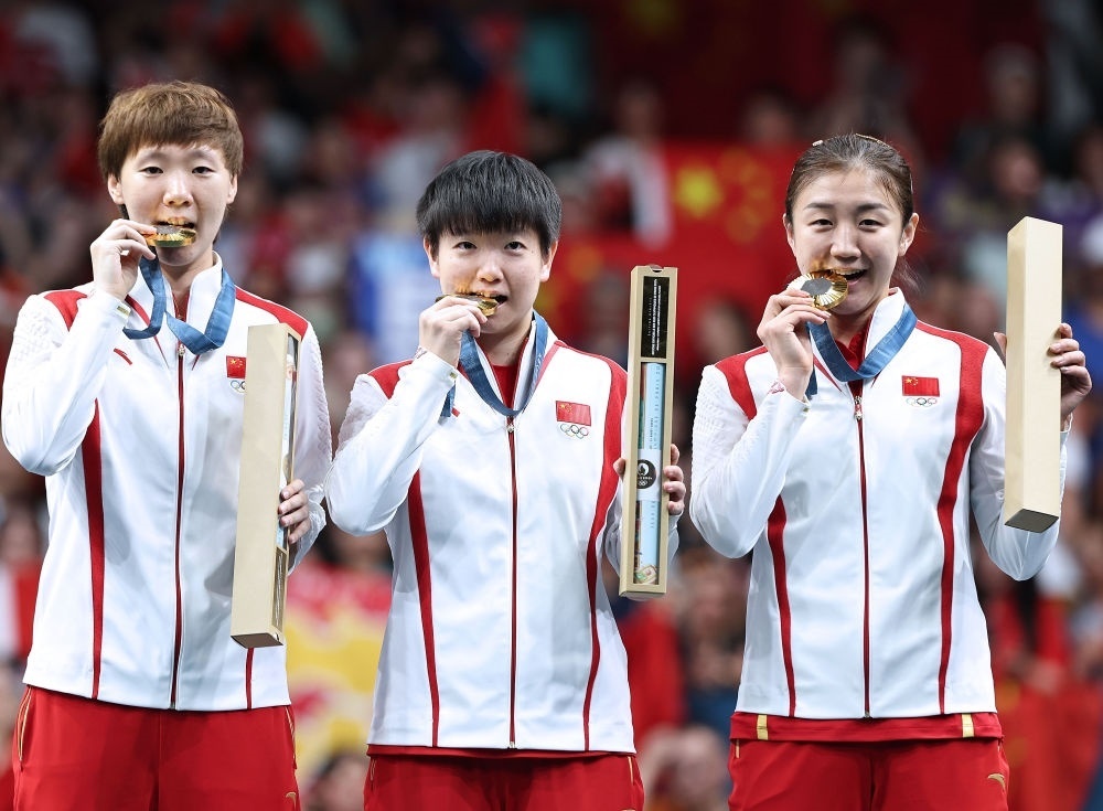 冠軍中國隊(duì)選手王曼昱、孫穎莎、陳夢（從左至右）在巴黎奧運(yùn)會(huì)乒乓球女子團(tuán)體頒獎(jiǎng)儀式上（2024年8月10日攝）。新華社記者 王東震 攝