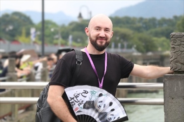 俄羅斯塔斯社執(zhí)行編輯葉夫根尼·扎多羅日內(nèi)在都江堰魚嘴拍照留念。（李佩藺 攝）