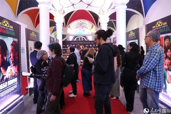 為期4天的第三屆中國－巴西電影展期間，來自中巴兩國的14部參展影片受到巴西電影愛好者和社會各界人士好評，圖為當(dāng)?shù)赜^眾在影展舉辦地巴西里約熱內(nèi)盧勞拉—阿爾維姆文化之家的迎賓廳欣賞參展電影海報(bào)。 人民網(wǎng)記者 陳一鳴攝