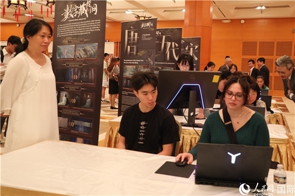 在活動(dòng)現(xiàn)場(chǎng)，當(dāng)?shù)孛癖婓w驗(yàn)“數(shù)字藏經(jīng)洞”云游戲，沉浸式體驗(yàn)敦煌文化。 人民網(wǎng)記者 李志偉攝