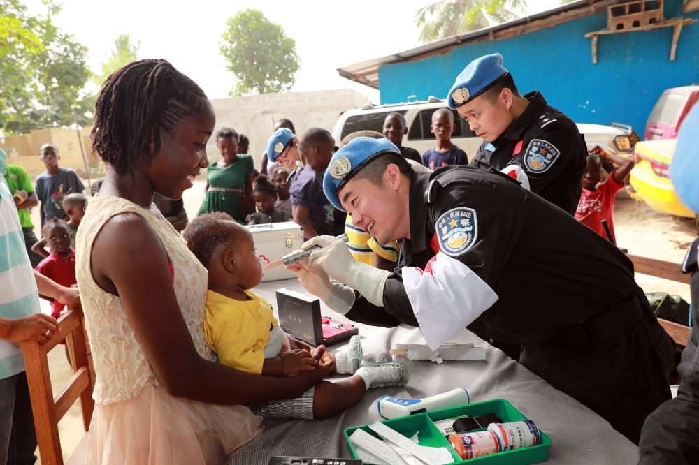 2017年12月28日，在利比里亞蒙羅維亞，中國維和警察防暴隊(duì)醫(yī)療人員為兒童做口腔檢查。