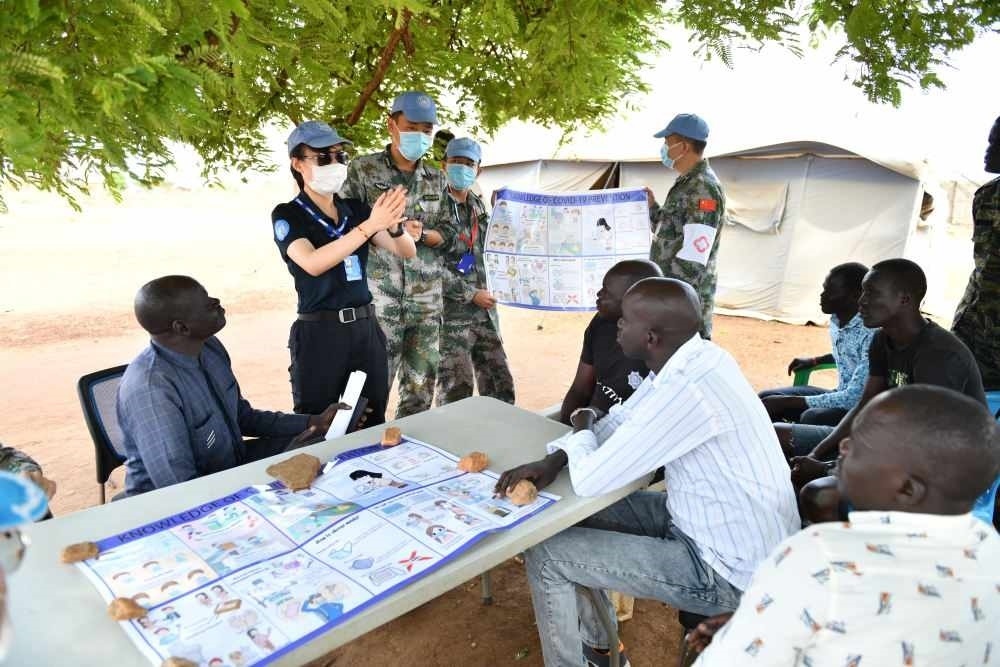 2020年3月，在南蘇丹首都朱巴，執(zhí)行聯(lián)合國維和任務(wù)的中國維和警察廖潔給當(dāng)?shù)鼐熘v解防疫知識(shí)。