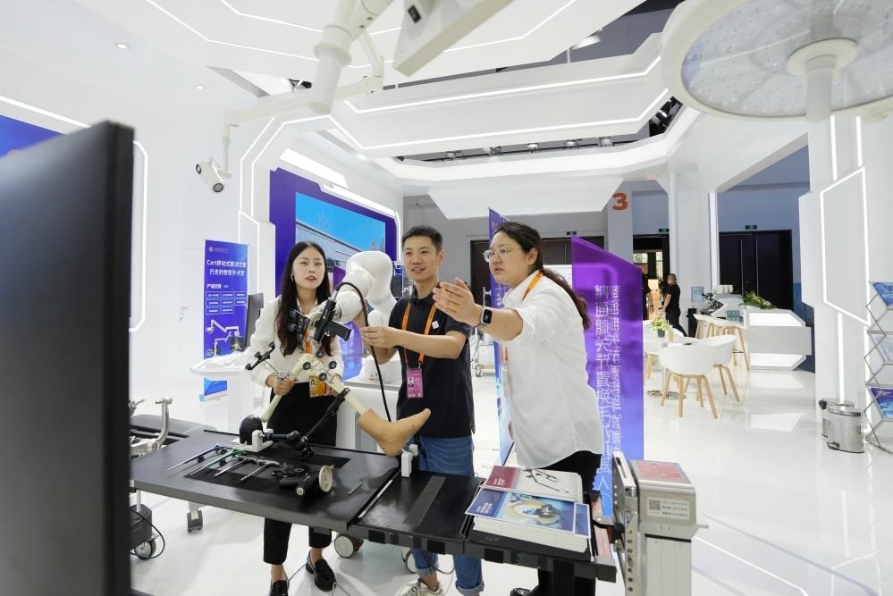 9月11日，一位媒體記者（中）在2024年服貿(mào)會(huì)國家會(huì)議中心會(huì)場體驗(yàn)北京納通科技集團(tuán)有限公司的膝關(guān)節(jié)置換手術(shù)機(jī)器人。新華社記者鞠煥宗 攝