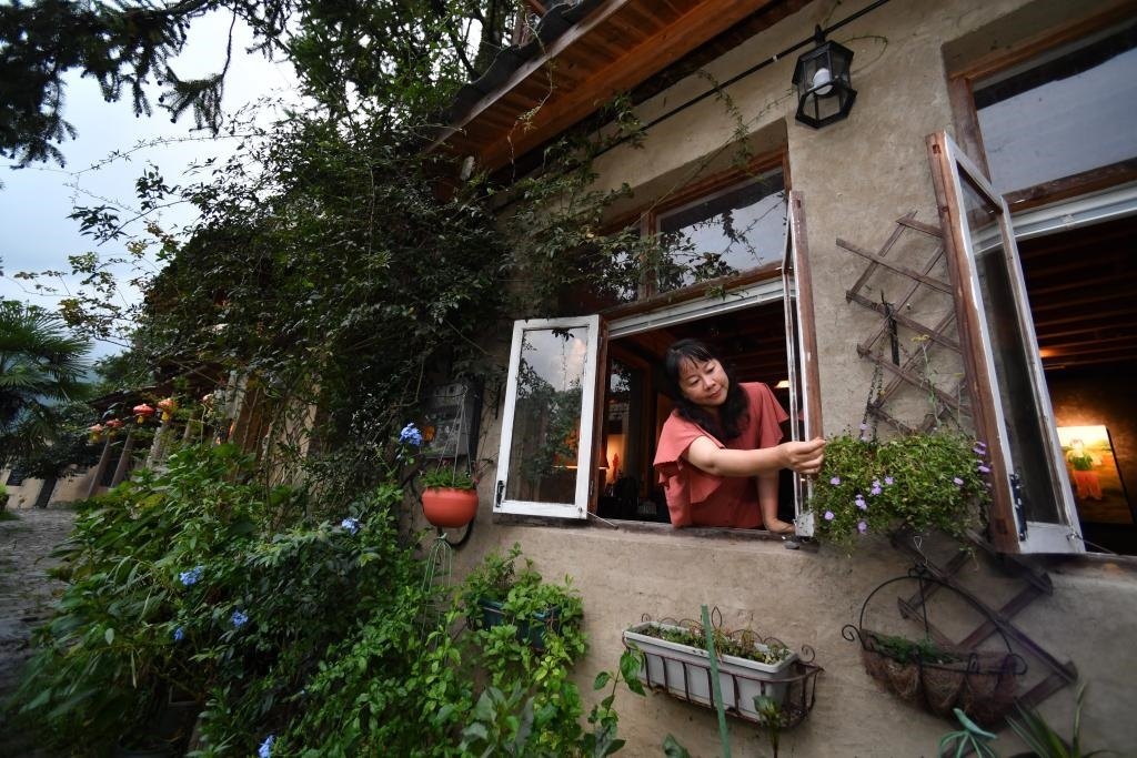 8月29日，在福建省屏南縣熙嶺鄉(xiāng)，龍?zhí)洞濉靶麓迕瘛泵泛暝诖蚶碜约航?jīng)營的民宿外墻裝飾花盆。新華社記者姜克紅 攝