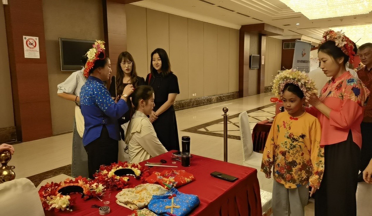 阿拉扎大學孔子學院志愿者老師向傳承人學習簪花圍。阿拉扎大學孔子學院供圖