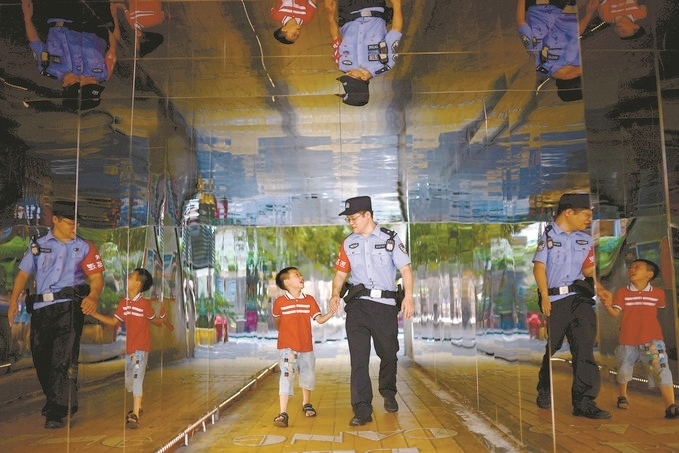 ?7月16日，重慶市公安局江北區(qū)分局一名民警在巡邏途中遇到一個(gè)獨(dú)自玩耍的小男孩，民警將其送回家。王洪平攝