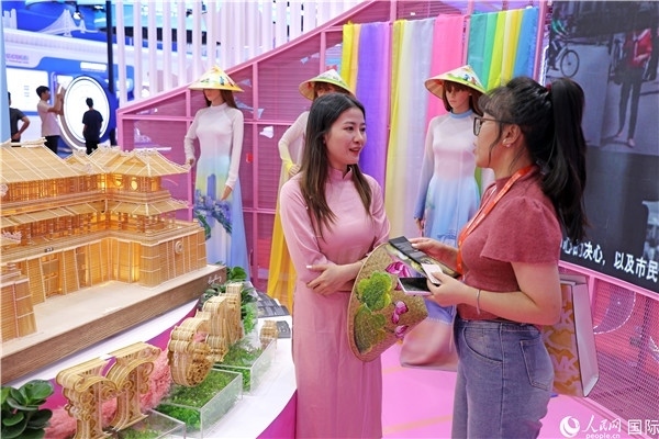 參觀者在東博會越南展區(qū)同工作人員咨詢交談。人民網(wǎng)記者 趙益普攝