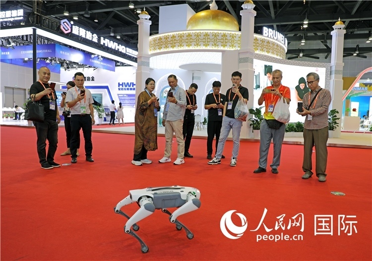 東博會上，觀眾正在參觀一只機(jī)器狗。綠色能源、新能源汽車、綠色農(nóng)產(chǎn)品等成為本屆東博會觀眾關(guān)注的焦點(diǎn)。人民網(wǎng)記者 趙益普攝