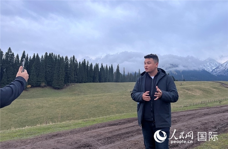 在庫爾德寧，吾買爾江被雪山美景震撼，即興錄制了短視頻作品。人民網(wǎng)記者曾書柔攝