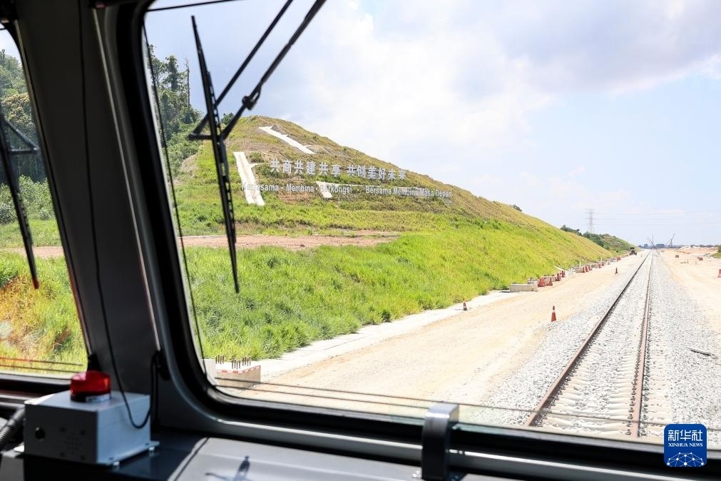 5月6日，在馬來西亞彭亨州馬東鐵項(xiàng)目沿途的山坡上，兩行中文和馬來文大字“共商共建共享，共創(chuàng)美好未來”映入眼簾。新華社記者 程一恒 攝