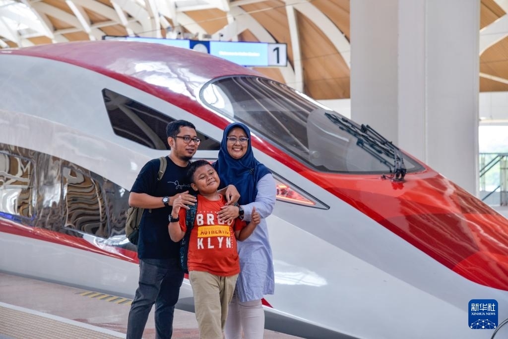 4月17日，在印度尼西亞雅加達(dá)哈利姆站站臺(tái)，乘客和雅萬高鐵高速動(dòng)車組列車合影。新華社記者 徐欽 攝