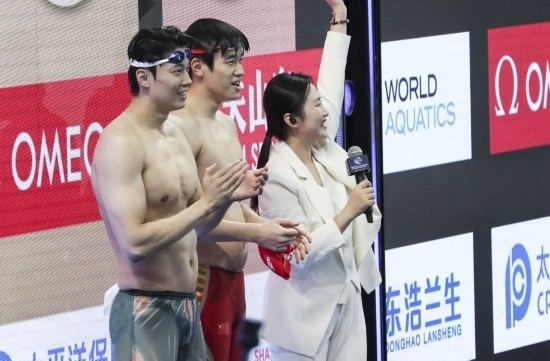  10月18日，汪順（左）和潘展樂在男子100米混合泳決賽后。新華社記者 方喆 攝
