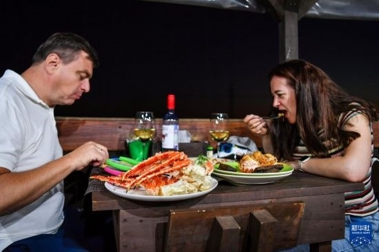 9月2日，食客們在俄羅斯符拉迪沃斯托克的一家餐館品嘗帝王蟹。新華社記者 曹陽 攝
