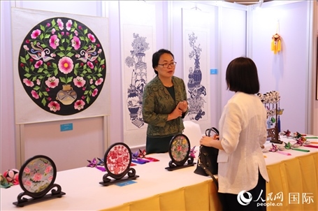 青海非遺文化傳承人向嘉賓介紹展品。人民網(wǎng)實(shí)習(xí)生姚欣可攝