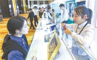 在北京麗澤商務(wù)區(qū)，工作人員（右一）介紹數(shù)字人民幣SIM卡硬錢包。新京報記者 陶冉攝