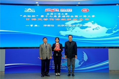 中國翻譯協(xié)會副會長中國外文局中東歐與中南亞傳播中心（人民畫報社）主任姜永鋼（右一）、原中國教育工會全國委員會巡視員白立文（左一）為獲得日語交傳組一等獎的北京外國語大學廖君怡頒獎（主辦方提供）