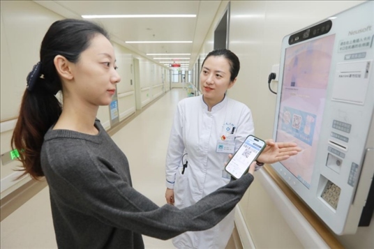 醫(yī)護(hù)人員引導(dǎo)患者在自助機(jī)前辦理自助入院手續(xù)。圖片來(lái)源：山東第一醫(yī)科大學(xué)第二附屬醫(yī)院