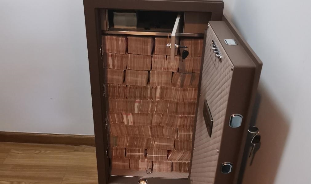 圖為警方查獲藏匿于保險柜中的現(xiàn)金。（警方供圖）