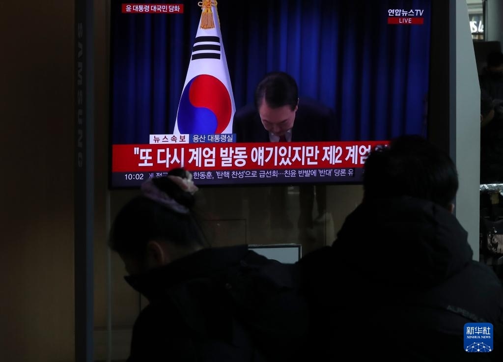 12月7日，在韓國(guó)首爾火車站，民眾觀看總統(tǒng)尹錫悅發(fā)表講話的電視畫面。新華社記者 姚琪琳 攝