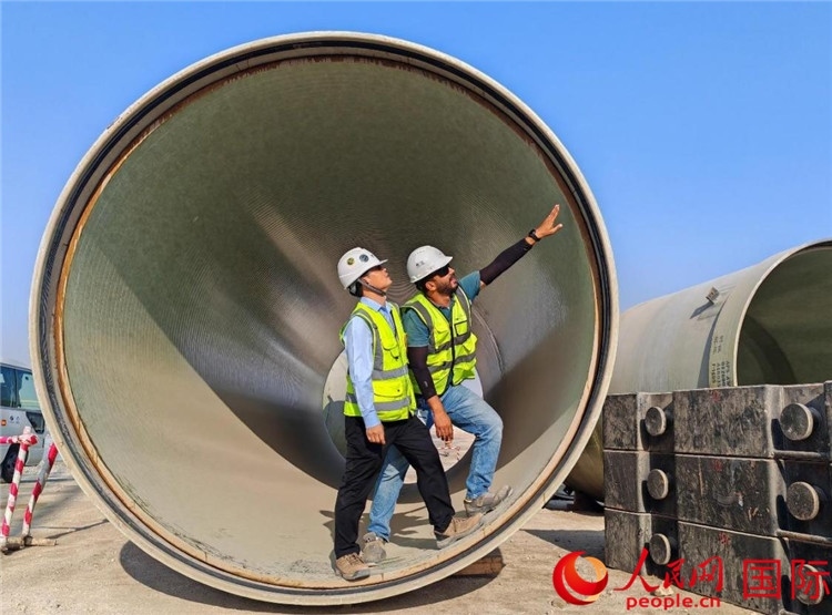 工作人員在察看輸水管情況。人民網(wǎng)記者 管克江攝